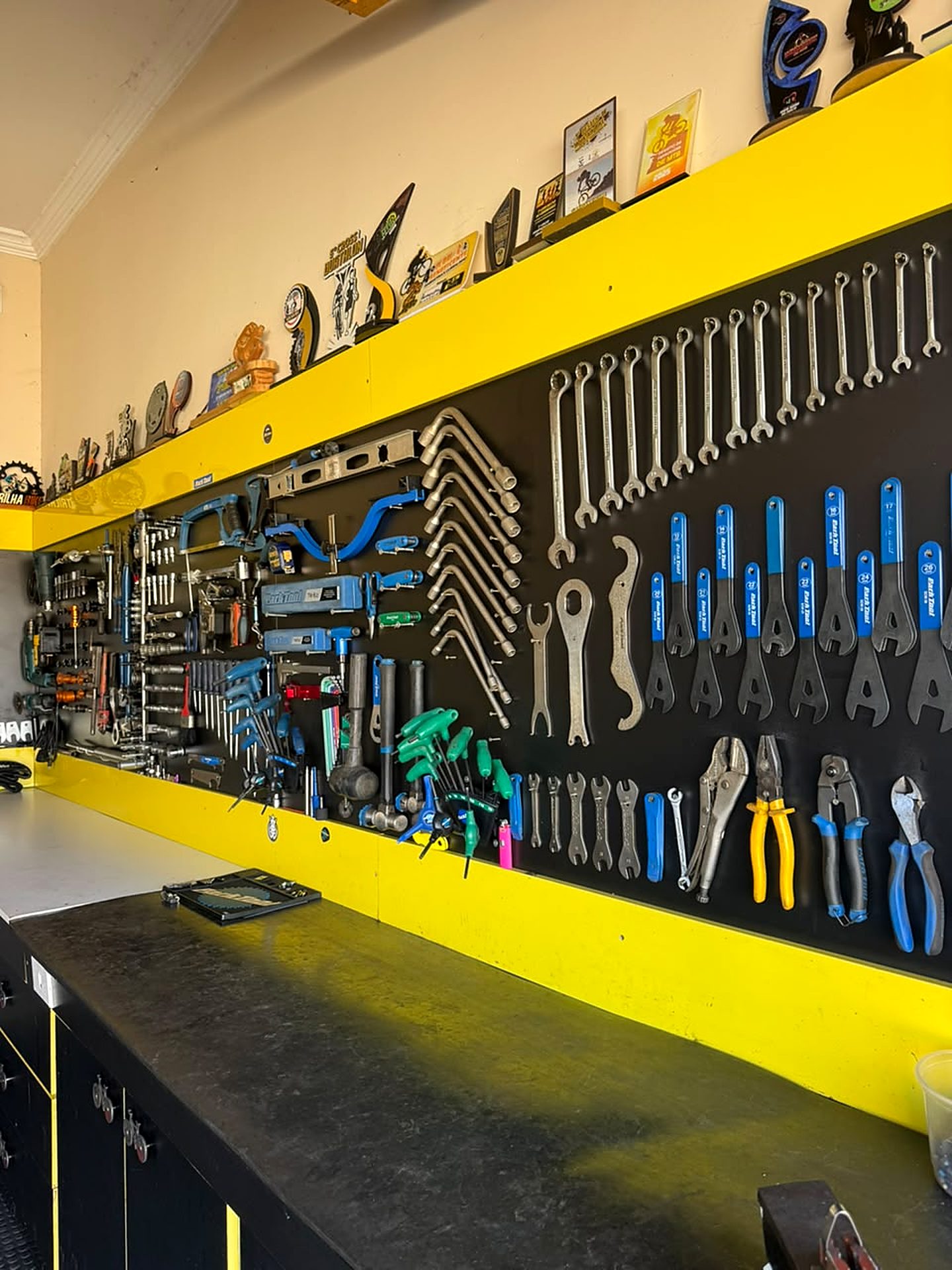 Parede de ferramentas organizada da oficina Ney Bikes